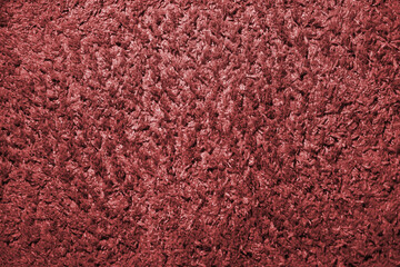 Close-up of the texture of a woolen carpet in red color