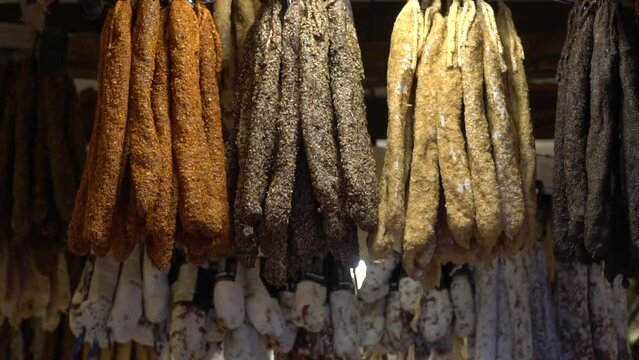 Air dried pepper fuet selling on the market. Close-up of sausages covered with garlic and pepper. Traditional sausage in spices in the farmers market. Sale of local meat products.