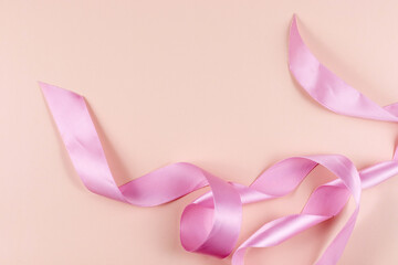 Pink satin ribbon on a pink background. High quality photo