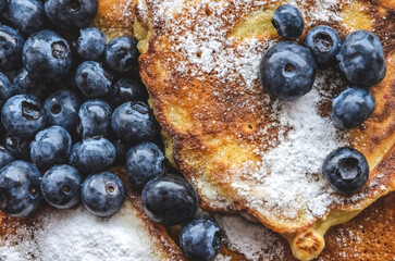 Delicious homemade pancakes with blueberries and powdered sugar, flat lay view from directly above