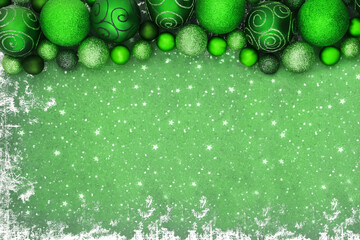 Christmas green sparkling bauble tree decorations on grunge background. Festive border composition...