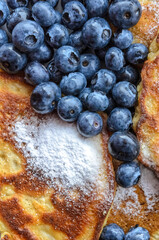 Delicious homemade pancakes with blueberries and powdered sugar, flat lay view from directly above