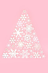 Fototapeta na wymiar Christmas tree sparkling snowflake and star design concept on pastel pink background. Festive abstract composition for winter, Xmas and New Year holiday season.