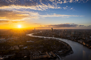 High panoramic sunset view of the urban skyline of London, England, with the river Thames leading into the City disctrict and beyond