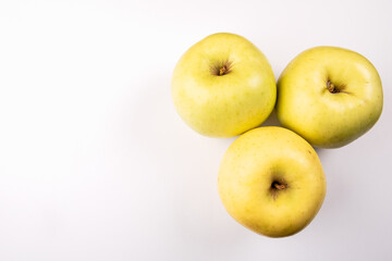 Three green and yellow apples on a white background. Healthy food and vitamins