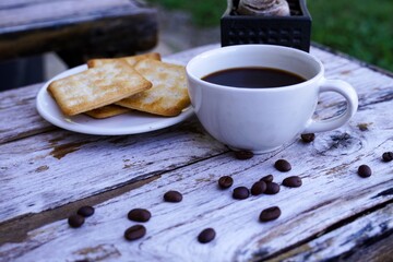 The hot black coffee in a white cup and the crackers are intense and go well together.