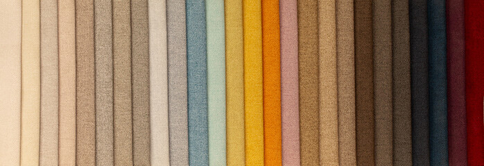 Fabric texture close up. Fabric swatches in different colors are stacked for selection. A variety...