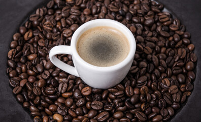 Roasted coffee espresso beans on dark plate background and cup with crema, close-up still life hot beverage, I love coffee concept