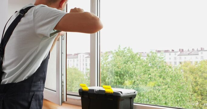 The worker installing and checking window in the house