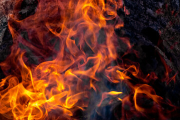 Burning fire close up. Bright orange and red flames on a dark background. Open flame heating. Problems with heating and gas.