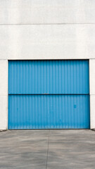 Fototapeta premium Puerta metálica azul en nave industrial de hormigón 