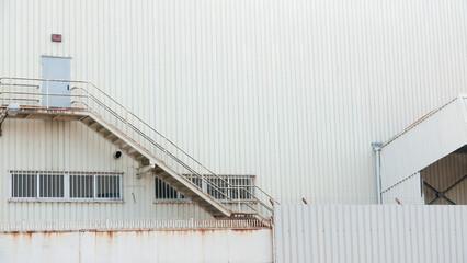 Escalera en fachada metálica de nave industrial