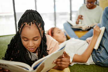 Education, study and learning students group of people studying for test, exam or doing research project on school campus. University, young college friends or a relax gen z black woman reading books - obrazy, fototapety, plakaty