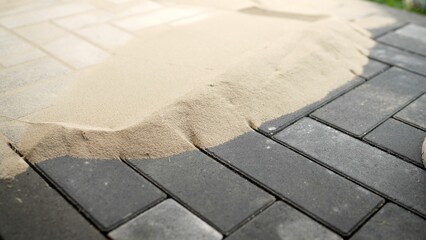 Laying tiles in the garden of the city park. Sand for paving slabs. Work on laying paving slabs in...