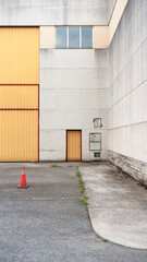 Puerta metálica naranja en nave industrial de hormigón 