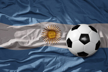 vintage football ball on the waveing national flag of argentina background. 3D illustration