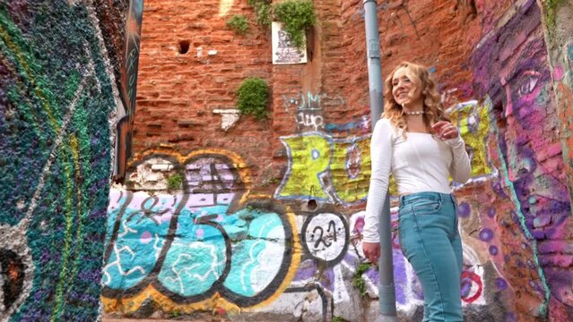 Blonde European tourist walking through the colorful graffiti walls and picturesque streets of Cerro Alegre, Valparaiso