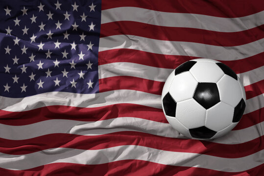 vintage football ball on the waveing national flag of united states of america background. 3D illustration