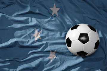 vintage football ball on the waveing national flag of Federated States of Micronesia background. 3D...