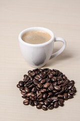 One single coffee cup or mug with whole roasted espresso beans and ground coffee on wooden desk or table, I like, love coffee, close-up, coffee making concept