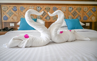 Two swans made of towels forming a heart.
