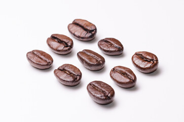 Rows of coffee beans order aligned, organization concept, close-up macro still life on white background