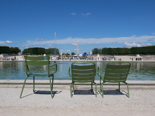 Paris, France: back view of three green iron garden chairs near the Octagonal Basin fountain in...