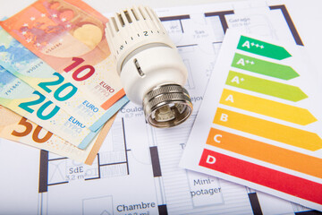 Energy saving concept house plan, money and thermostat in France
