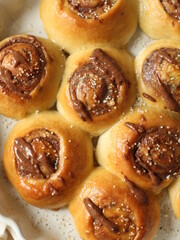 Vegan cinnamon rolls with peanut butter drizzle and course sugar close-up top view