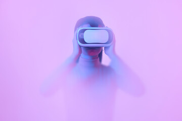 Young girl wearing VR headset immersed in backlit diffuse liquid. Concept of art, metaverse, modern...