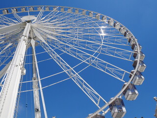 Paris, France: low angle view of the Paris ferris wheel against clear blue sky - Powered by Adobe