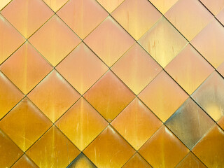 Golden yellow brass tiles wall background.