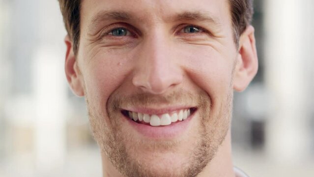 Portrait, happiness and a smile closeup of a man with a friendly face looking happy and having a positive mindset. Male with looking content, showing teeth and blue eyes while smiling in England