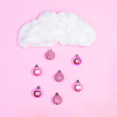 Creative cloud with raining pink Chrismtas ornaments on pastel pink background. Flat lay