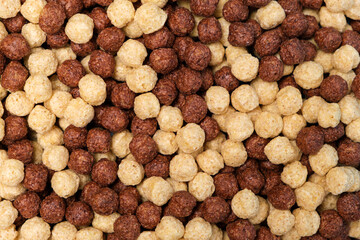 Breakfast cereal - corn and wheat balls with cocoa on a blue background, top view