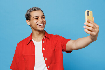 Young man of African American ethnicity wear red shirt do selfie shot on mobile cell phone post...