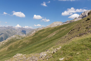 Picturesque view of the Pyrenees landscape with green meadows and mountains during the day. Summer trip in the mountains