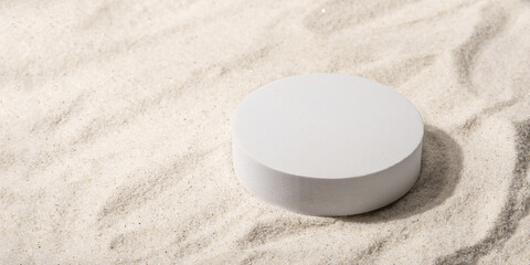 Fototapeta na wymiar Natural cosmetic background for product presentation. White podium on the sand. Front view.