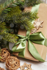 Fototapeta na wymiar Eco Christmas holiday background. Craft paper gift box, present, wooden decor. Christmas lights.
