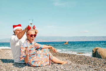 Funny adult couple wearing christmas costumes drinking sparkling wine and enjoying christmas...