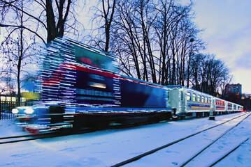 Kyiv, Ukraine-January 22, 2022:Blurred Christmas illuminated train. Train arrived at the station. Holiday decorations of train. Narrow gauge Kyiv Children's Railway in Syretsky Park