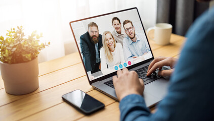 Laptop screen view over man shoulder at group video call. Communication between business people distantly using webcam internet connection app. Working remote chat concept