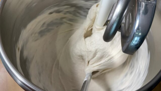 The process making homemade bread. The yeast is ready for making bread. The sourdough dough for craft bread. Making bread using traditional technique. Yeast-free bread is kneaded in a dough mixer.