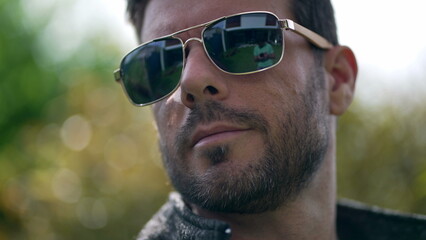 Handsome young man wearing sunglasses outdoors. Closeup face of male person with eye glass