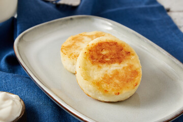 Cottage cheese pancakes with sour cream, closeup