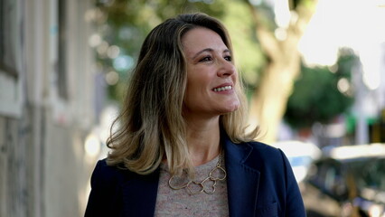 Happy middle age woman walking in street in street. Mindful 50s person walking forward in...