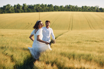 Couple just married. Together on the majestic agricultural field at sunny day