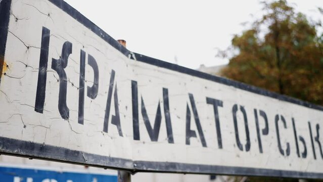 Ukraine war. Dead End sign with rusty bullet holes against blue sky - rack focus