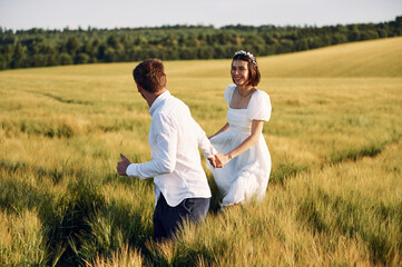 Enjoying the walk. Couple just married. Together on the majestic agricultural field at sunny day
