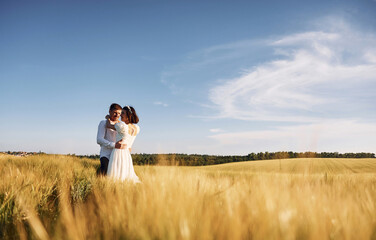 Conception of love. Couple just married. Together on the majestic agricultural field at sunny day